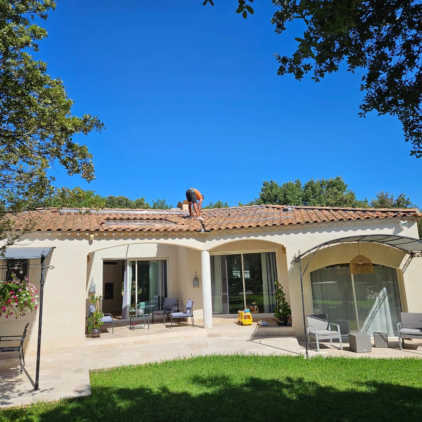 Technicien d’Indépendance Énergétique posant des panneaux sur une villa provençale à arcades