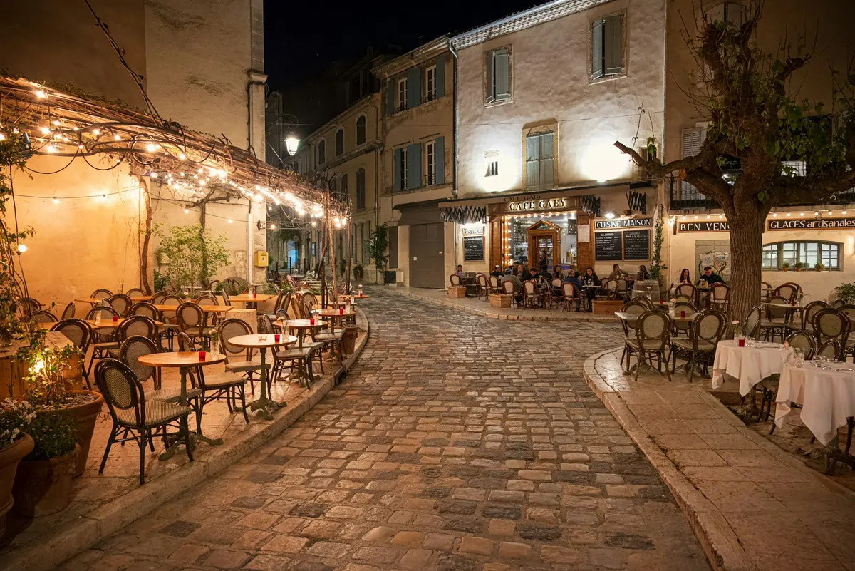 Rue et terrasse éclairées la nuit à Lourmarin, dans le Luberon
